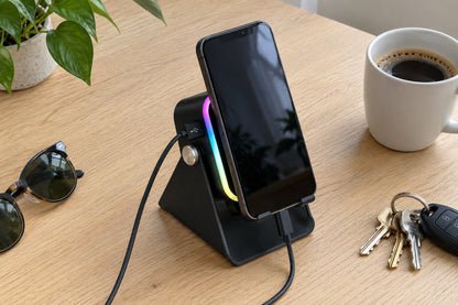 The ECDF Induction Speaker Stand with a phone on a light oak desk next to sunglasses, keys and a coffee cup