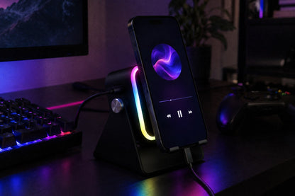 The ECDF Induction Speaker Stand glowing pink and blue on a gaming desk next to a keyboard