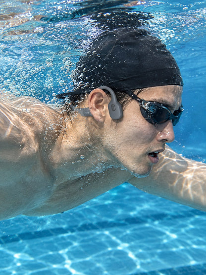 Underwater view of a swimmer doing freestyle while wearing the ECDF Open-Ear Swim Headphones