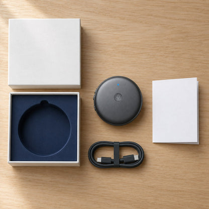 The ECDF translator laid out next to its open gift box, a charging cable and a card